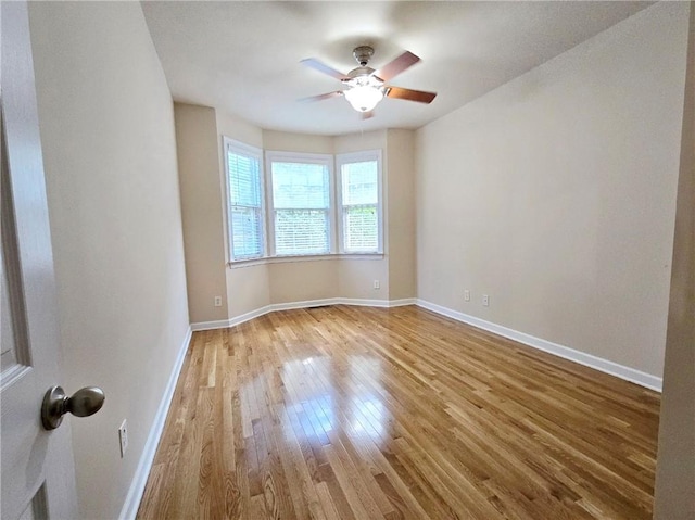 unfurnished room featuring wood finished floors, baseboards, and ceiling fan