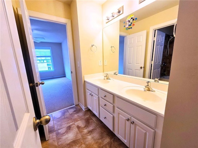 bathroom featuring baseboards, a sink, and double vanity