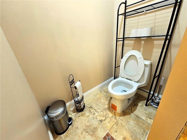 bathroom featuring baseboards and toilet