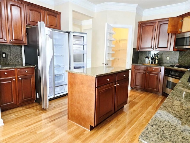 kitchen featuring decorative backsplash, light wood-style floors, appliances with stainless steel finishes, and crown molding