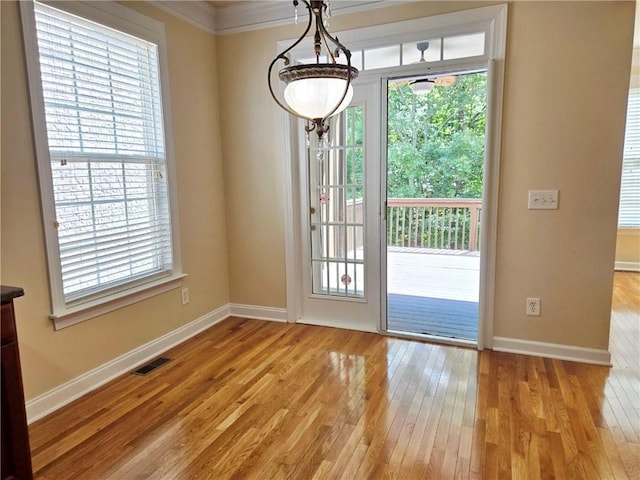 doorway featuring plenty of natural light, baseboards, and light wood-style flooring