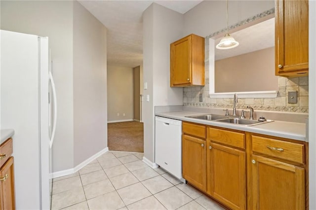 kitchen with pendant lighting, white appliances, tasteful backsplash, and sink