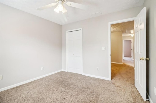 unfurnished bedroom with light carpet, a closet, and ceiling fan