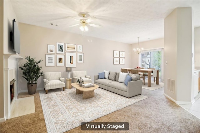 living room featuring ceiling fan with notable chandelier and light carpet