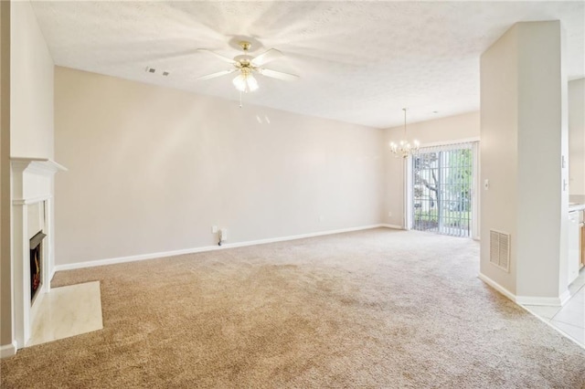 unfurnished living room featuring ceiling fan with notable chandelier and light colored carpet