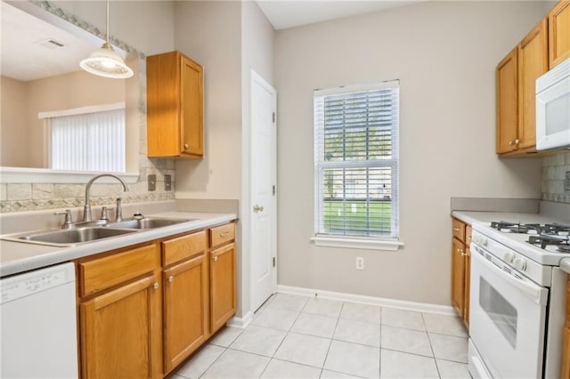 kitchen featuring tasteful backsplash, white appliances, sink, light tile patterned floors, and hanging light fixtures