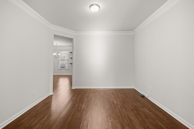 unfurnished room featuring baseboards, a notable chandelier, dark wood finished floors, and ornamental molding