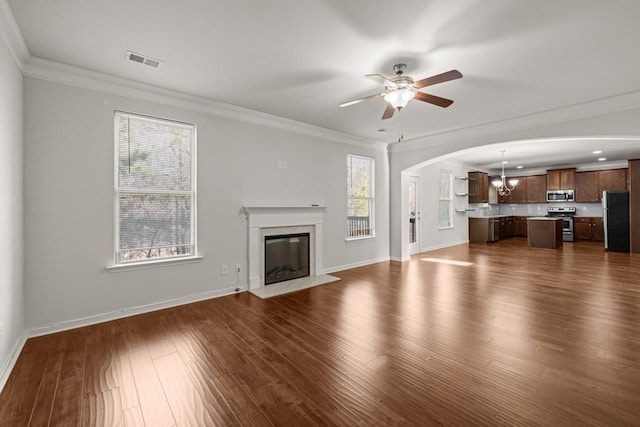 unfurnished living room with visible vents, plenty of natural light, dark wood-type flooring, and a fireplace