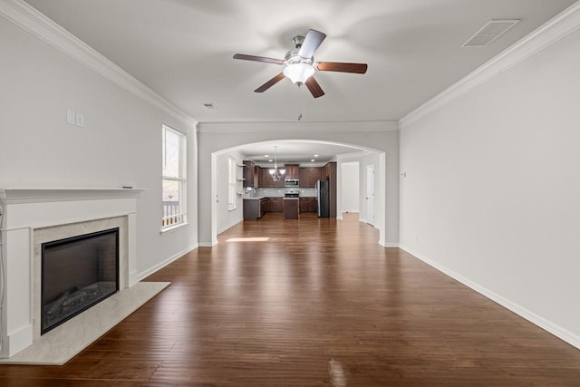 unfurnished living room featuring visible vents, dark wood-type flooring, a premium fireplace, and ornamental molding