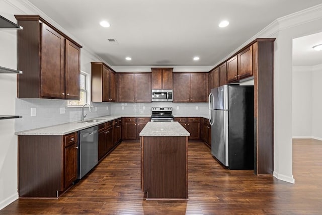 kitchen with visible vents, dark wood finished floors, a sink, stainless steel appliances, and crown molding