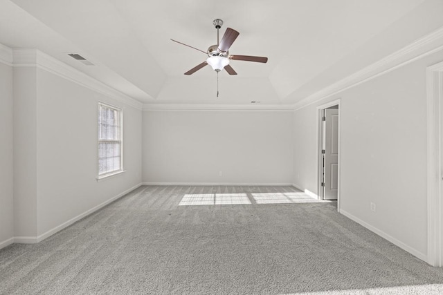 carpeted spare room with visible vents, baseboards, ornamental molding, a raised ceiling, and a ceiling fan