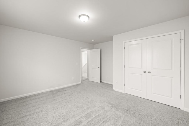 unfurnished bedroom featuring a closet, baseboards, and carpet floors