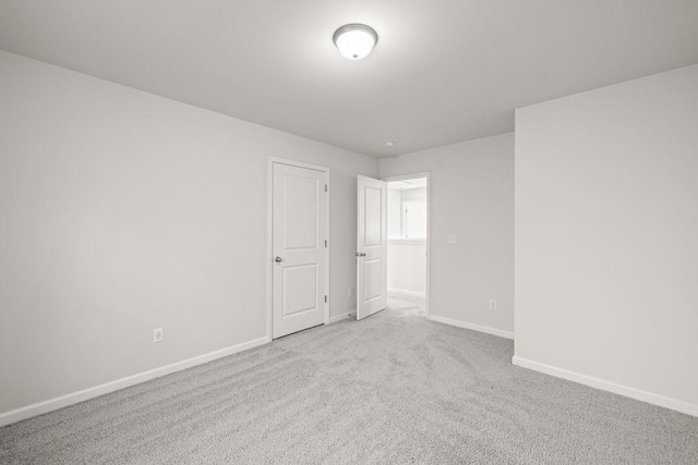 carpeted empty room with baseboards