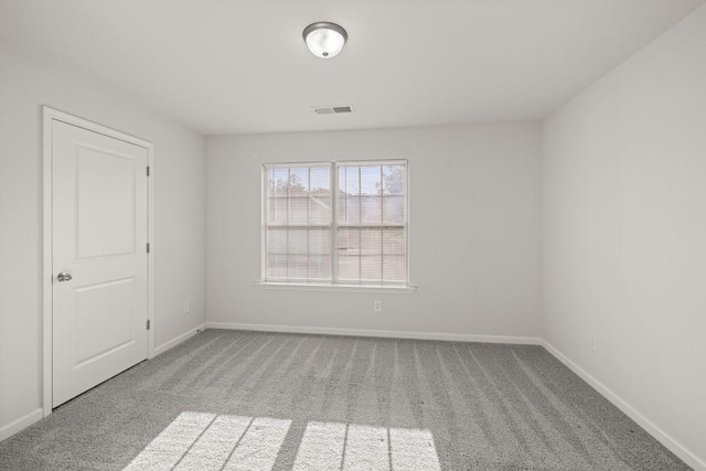 unfurnished room with visible vents, baseboards, and carpet