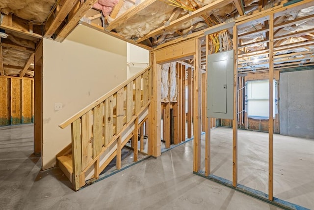 basement featuring stairs and electric panel