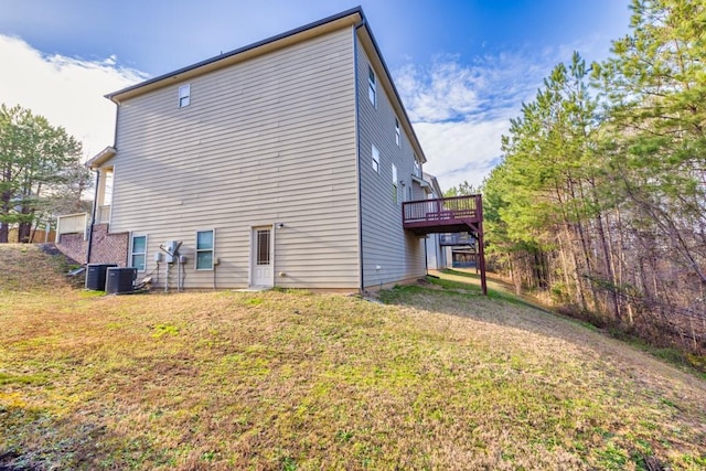 back of house featuring central air condition unit, a yard, and a wooden deck