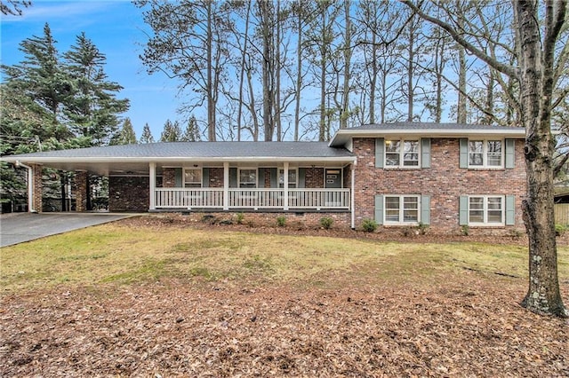 tri-level home featuring a carport, a porch, and a front lawn