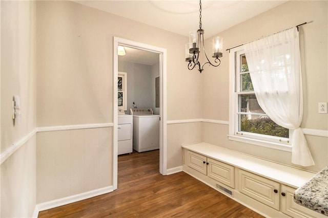 unfurnished dining area featuring a notable chandelier, dark wood-type flooring, and washer and clothes dryer