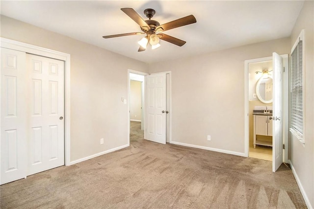 unfurnished bedroom featuring ceiling fan, a closet, light carpet, and connected bathroom