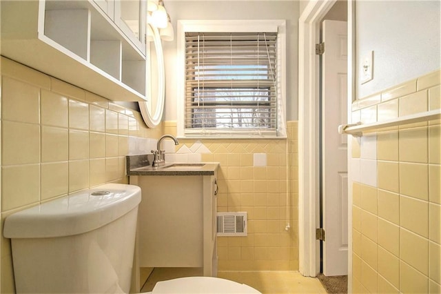 bathroom featuring tile walls, toilet, and vanity