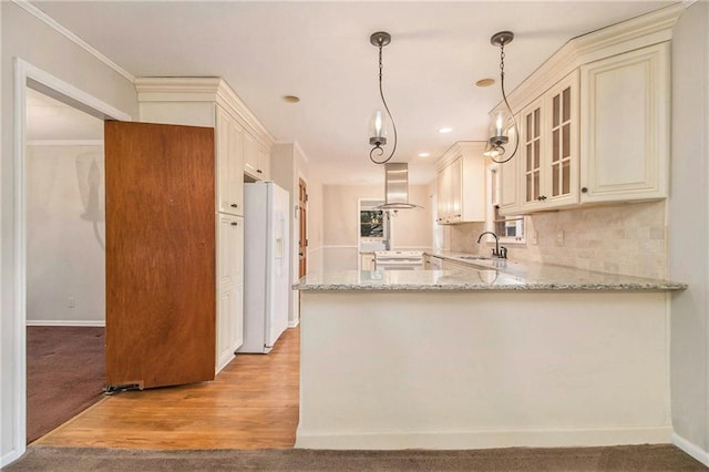 kitchen with kitchen peninsula, hanging light fixtures, light stone countertops, white appliances, and island range hood