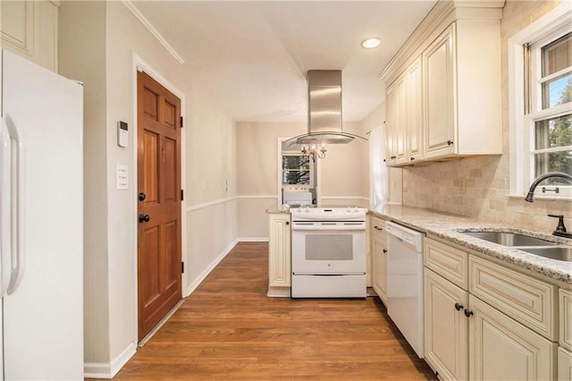 kitchen featuring white appliances, range hood, cream cabinetry, and sink