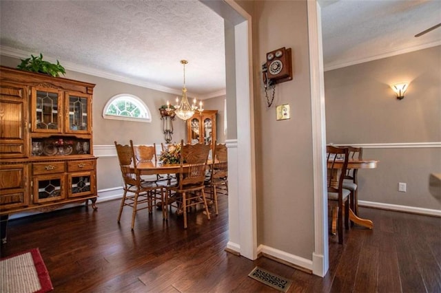 dining area with a notable chandelier, a textured ceiling, crown molding, and dark hardwood / wood-style flooring