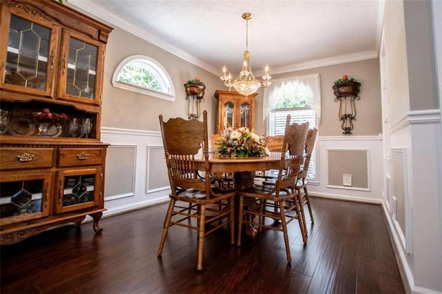 dining space featuring dark wood-type flooring, ornamental molding, and an inviting chandelier