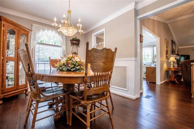 dining room with lofted ceiling, a chandelier, dark hardwood / wood-style floors, and ornamental molding