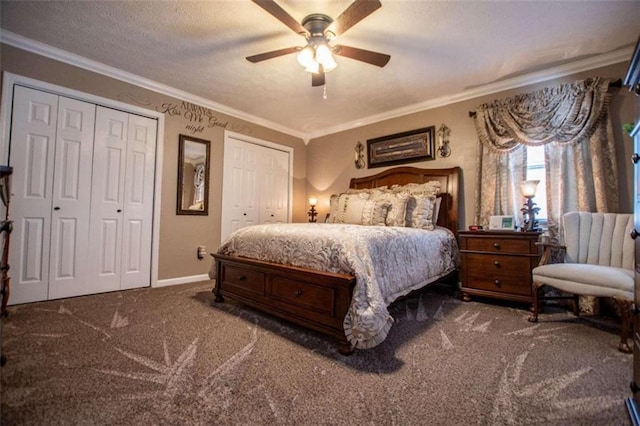 carpeted bedroom featuring crown molding, two closets, and ceiling fan