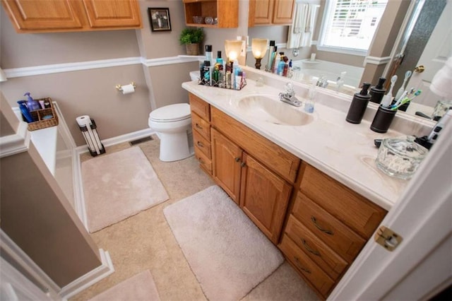 bathroom featuring a bathtub, tile flooring, oversized vanity, and toilet