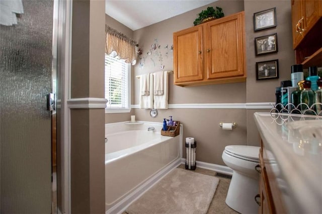 bathroom with a washtub, vanity, toilet, and tile flooring