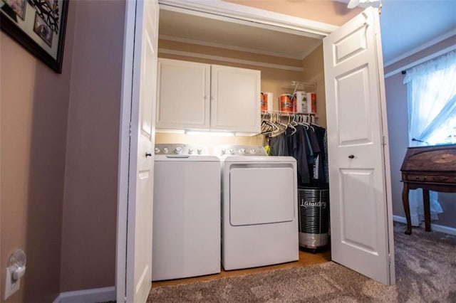 laundry area featuring ornamental molding, washer and dryer, carpet flooring, and cabinets