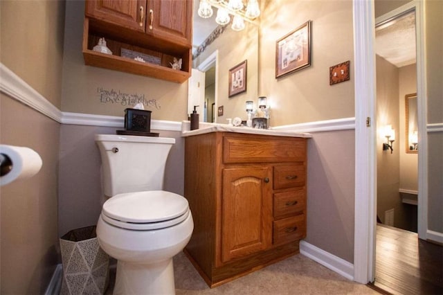 bathroom featuring a chandelier, vanity, and toilet