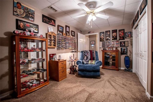 sitting room featuring carpet, ceiling fan, and a paneled ceiling