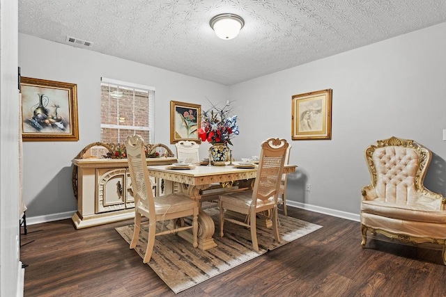 dining area with a textured ceiling and dark hardwood / wood-style flooring