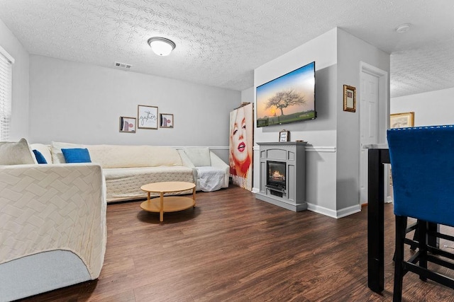 living room with dark hardwood / wood-style floors and a textured ceiling