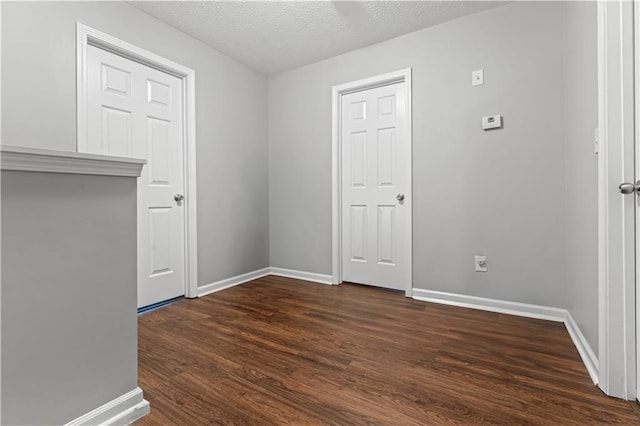 empty room featuring dark wood-type flooring and a textured ceiling