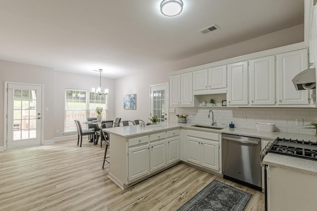 3329 Walt Stephens Rd, Stockbridge, GA 30281 - kitchen with stainless steel dishwasher, a peninsula, a chandelier, light wood finished floors, and backsplash