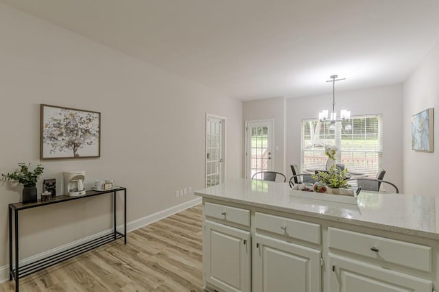 3329 Walt Stephens Rd, Stockbridge, GA 30281 - kitchen featuring a chandelier, light wood-type flooring, pendant lighting, and light stone countertops