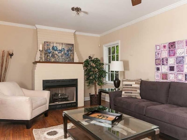 living room with ornamental molding, a brick fireplace, and dark hardwood / wood-style floors