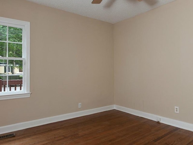 spare room featuring a textured ceiling, dark hardwood / wood-style flooring, and ceiling fan