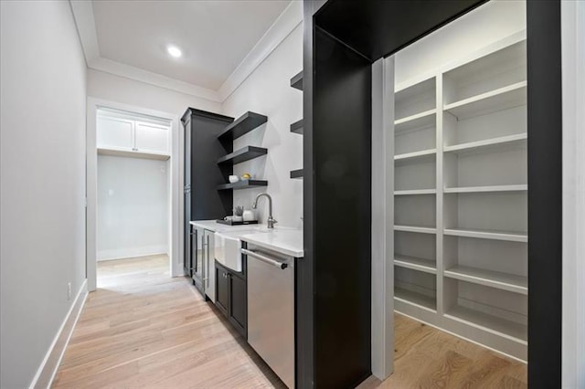 bar featuring light wood-style floors, crown molding, baseboards, and stainless steel dishwasher