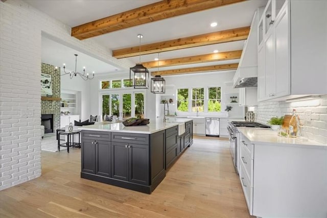 kitchen with light wood finished floors, stainless steel appliances, light countertops, custom range hood, and white cabinets