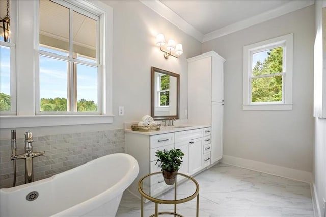 bathroom featuring vanity, baseboards, a freestanding bath, marble finish floor, and crown molding