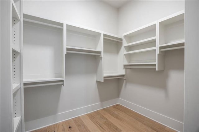 walk in closet with wood finished floors