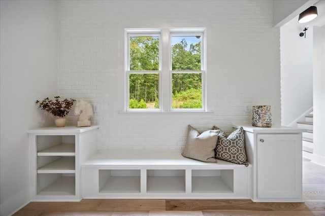 mudroom featuring brick wall