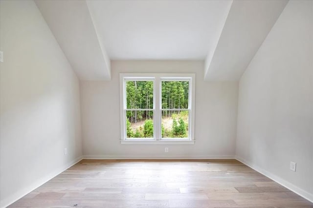 bonus room featuring light wood-style floors and baseboards