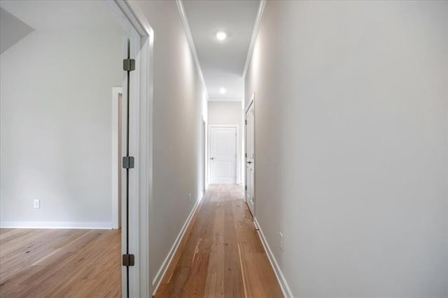 hallway with light wood-style floors, recessed lighting, baseboards, and ornamental molding