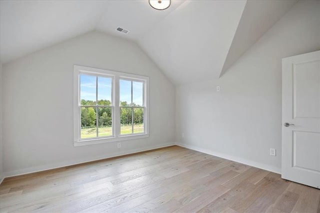 bonus room with lofted ceiling, light wood finished floors, visible vents, and baseboards